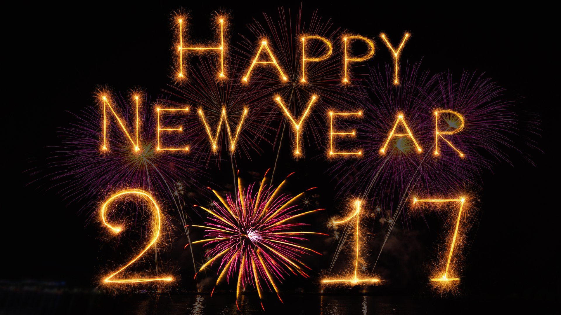 HD desktop wallpaper featuring vibrant fireworks with glowing Happy New Year 2017 text, celebrating the holiday with a festive display.
