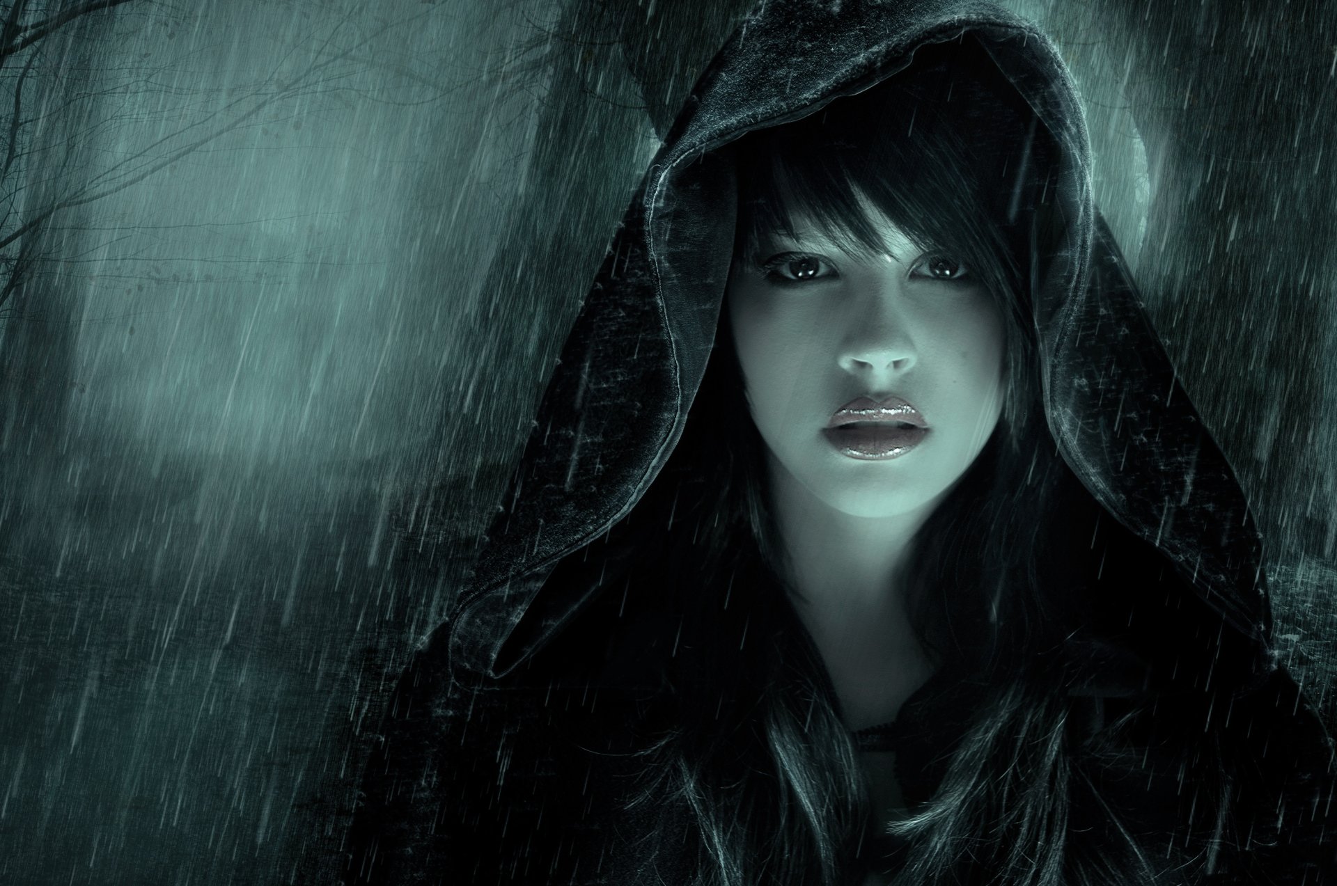 HD desktop wallpaper of an artistic scene featuring a woman in a hood standing in the rain, with a moody and atmospheric backdrop.