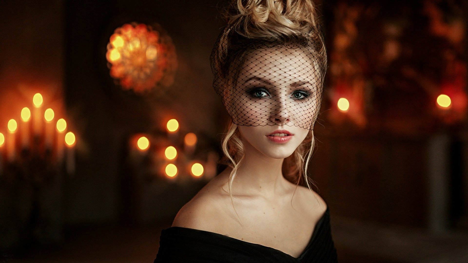 HD desktop wallpaper featuring a blonde woman with green eyes wearing a black veil, captured in a softly lit, warm-toned setting.