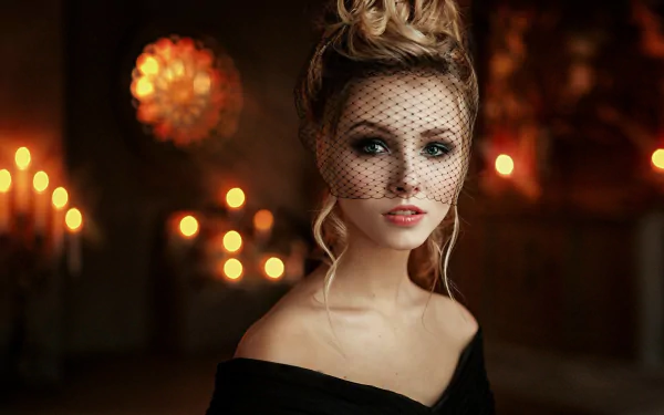 HD desktop wallpaper featuring a blonde woman with green eyes wearing a black veil, captured in a softly lit, warm-toned setting.