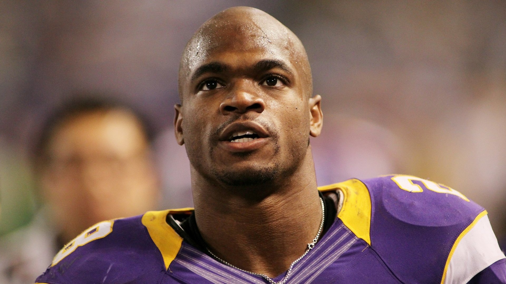 HD wallpaper featuring an athlete in a purple and gold football uniform, serving as a dynamic desktop background.