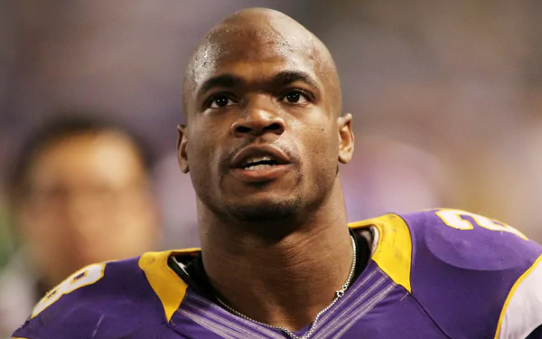 HD wallpaper featuring an athlete in a purple and gold football uniform, serving as a dynamic desktop background.