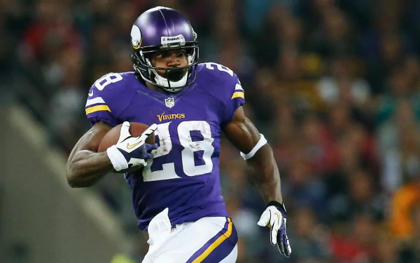 HD wallpaper of a player in a purple Vikings uniform with the number 28, in action on the football field.