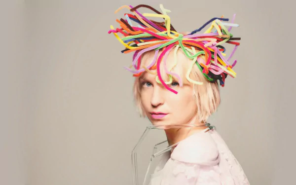 HD wallpaper of a person with multicolored tubular hair accessories on a beige background, used as a desktop background.