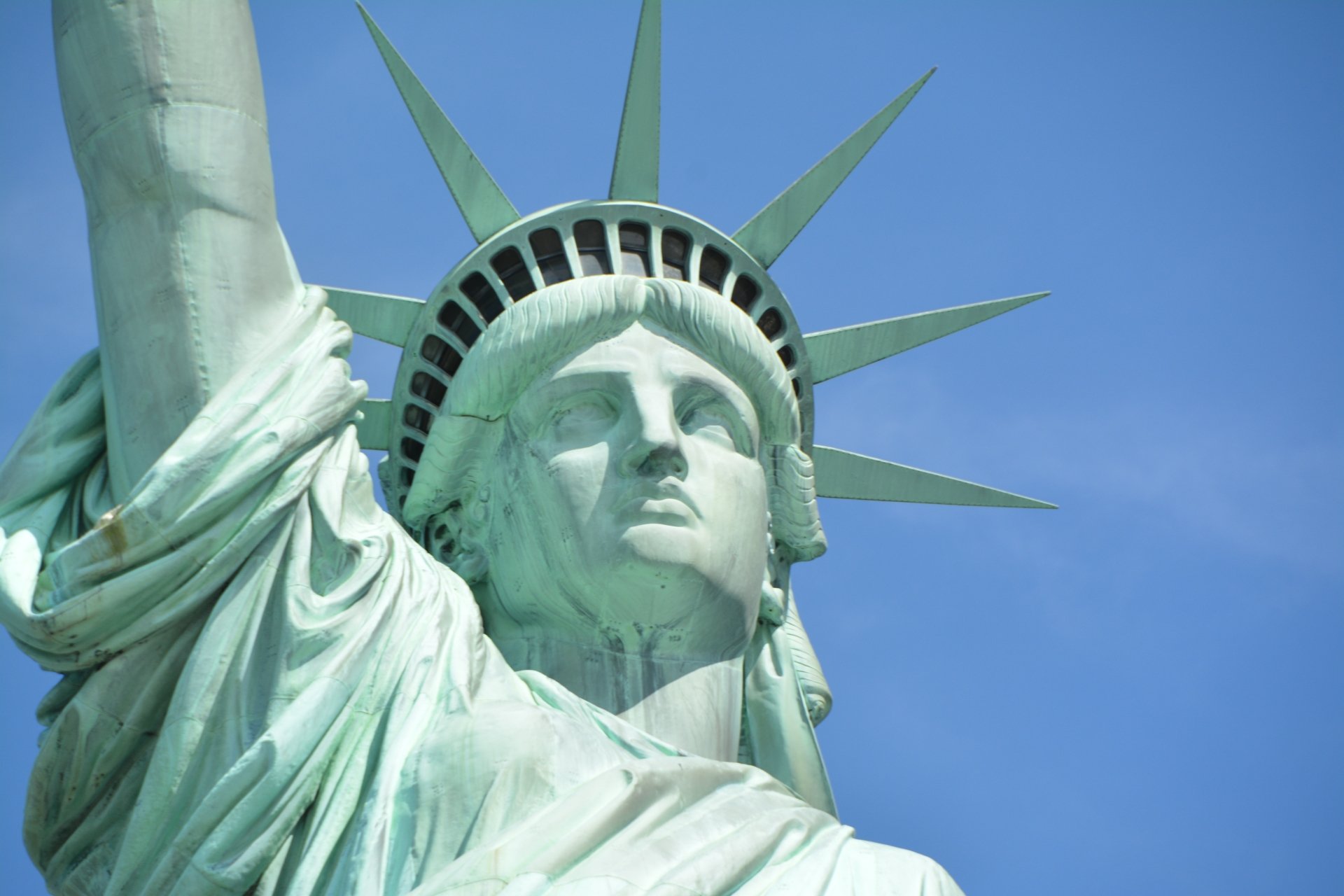 Close-up view of the Statue of Liberty, a man-made monument in New York, USA, shown in 4K Ultra HD detail against a clear blue sky.