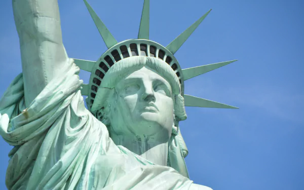 Close-up view of the Statue of Liberty, a man-made monument in New York, USA, shown in 4K Ultra HD detail against a clear blue sky.