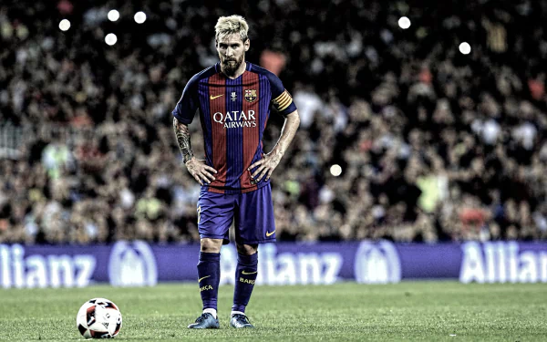 HD desktop wallpaper and background image featuring Lionel Messi on the soccer field, wearing a Barcelona jersey and looking down at a ball with a focused expression.