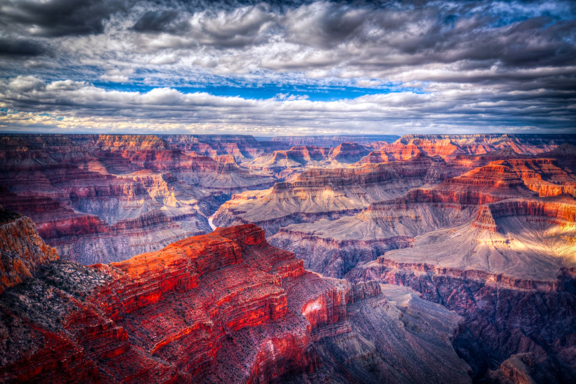 HDR 2K Quad HD PC desktop wallpaper and background: dramatic canyon landscape with layered rock formations, wide horizon and cloud-filled sky in vivid colors.