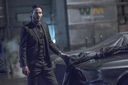 HD desktop wallpaper featuring Keanu Reeves as John Wick in John Wick: Chapter 2, standing beside a car in a dark, city street scene.