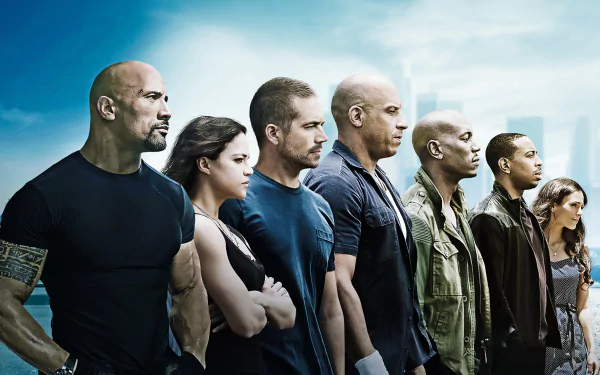 HD desktop wallpaper featuring the main cast of the movie Furious 7, standing side by side against a cloudy sky backdrop.