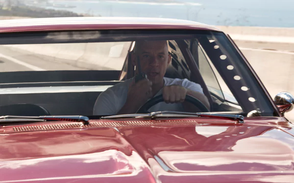 HD desktop wallpaper of Dominic Toretto, played by Vin Diesel, from the movie Fast & Furious 6, driving a car and speaking into a walkie-talkie.