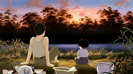 HD anime desktop wallpaper from Grave of the Fireflies, depicting two characters sitting by a riverside at sunset with lush trees and a vibrant sky.