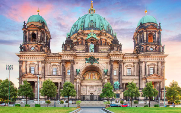 4K Ultra HD desktop wallpaper of Berlin Cathedral, Germany — majestic religious architecture with green domes and ornate façade bathed in warm sunrise light.