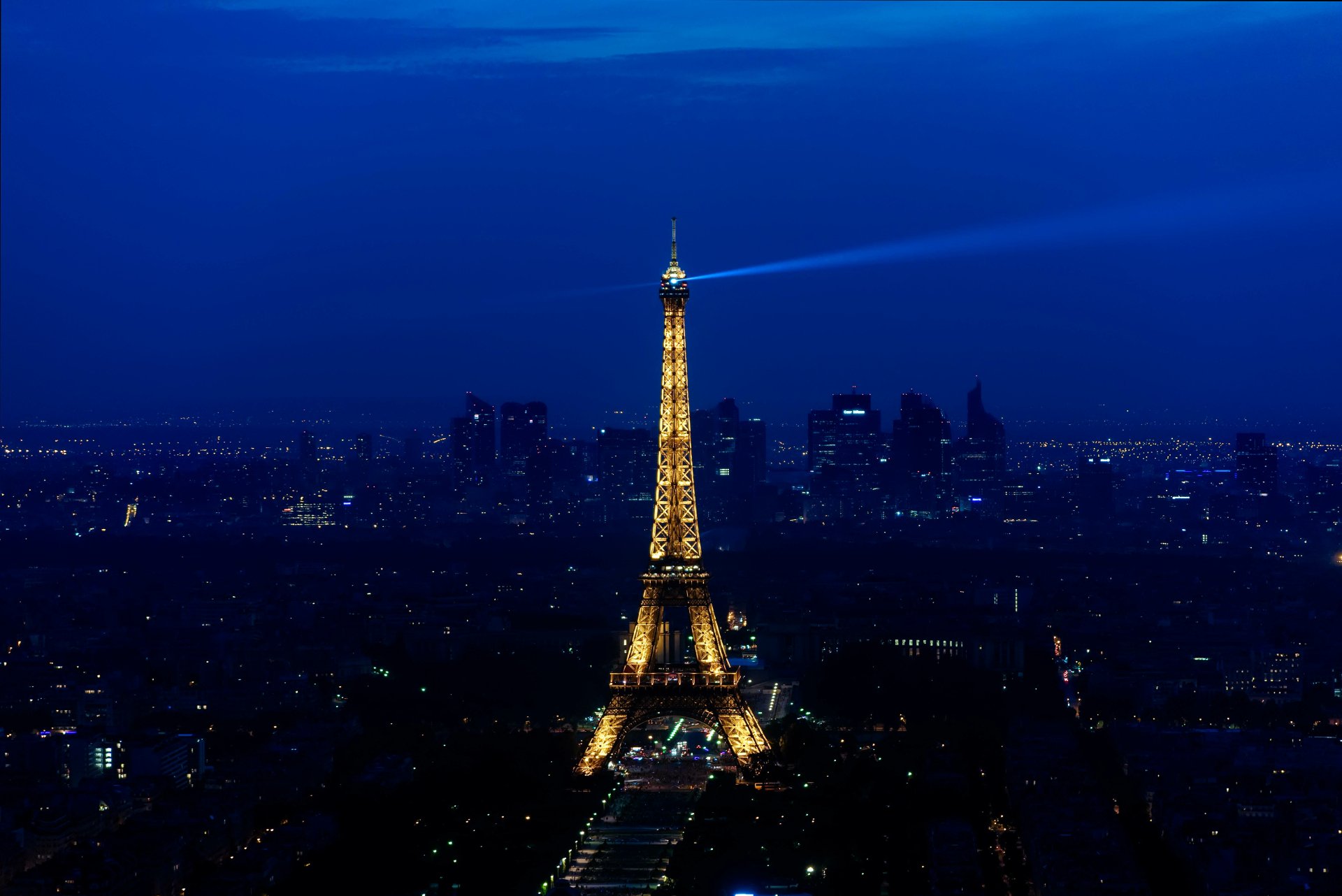 A stunning 4K Ultra HD night cityscape of Paris, France, showcasing the illuminated Eiffel Tower against a deep blue sky.