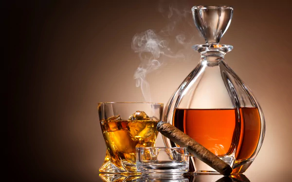 4K Ultra HD still life of a glass and decanter filled with amber alcohol, accompanied by a lit cigar resting on an ashtray, against a warm brown background.
