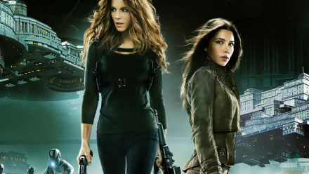 HD PC desktop wallpaper of two women action stars armed and standing before a futuristic cityscape — promotional art for the movie Total Recall (2012).