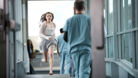 HD PC desktop wallpaper from the movie If I Stay: a young woman in a dress runs barefoot down a hospital corridor toward medical staff.