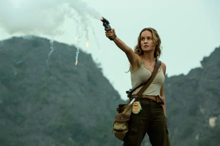 HD desktop wallpaper and background featuring Brie Larson from the movie Kong: Skull Island, standing amidst mountains, holding up a flare gun.