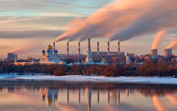HD desktop wallpaper of a winter scene in Russia featuring a reflection of a power plant with smoke plumes and surrounding architecture on a calm body of water.