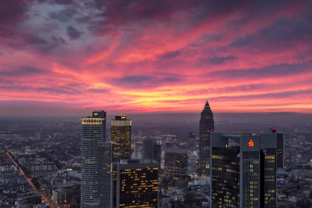 HD desktop wallpaper of Frankfurt, Germany — man-made skyline of skyscrapers and buildings against dramatic pink-orange sunset clouds on the horizon.