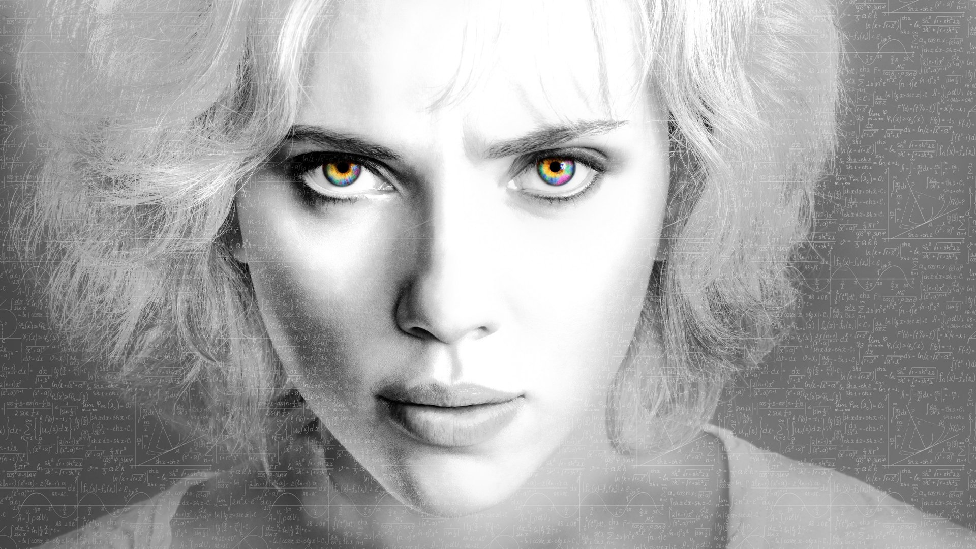Close-up grayscale portrait of Scarlett Johansson as Lucy with striking multicolored eyes, featured as an HD PC desktop wallpaper and background.