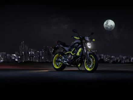A Yamaha MT-07 motorcycle with neon yellow accents is parked at night against a city skyline and full moon, captured in 4K Ultra HD for desktop wallpaper use.