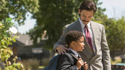 HD PC desktop wallpaper of a scene from the TV show This Is Us: a suited man gently places a hand on a schoolboy's shoulder as they stand outside.
