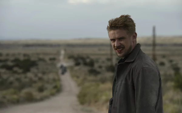 HD desktop wallpaper featuring Boyd Holbrook in a scene from the movie Logan, set against a vast, arid landscape with a dirt road stretching into the distance.