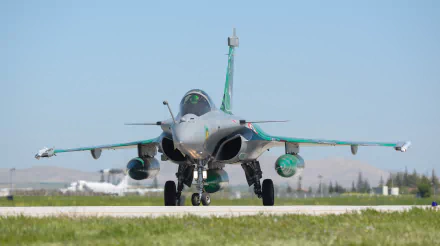 Front view of a Dassault Rafale jet fighter warplane on a runway, captured in 4K Ultra HD with a clear sky backdrop.
