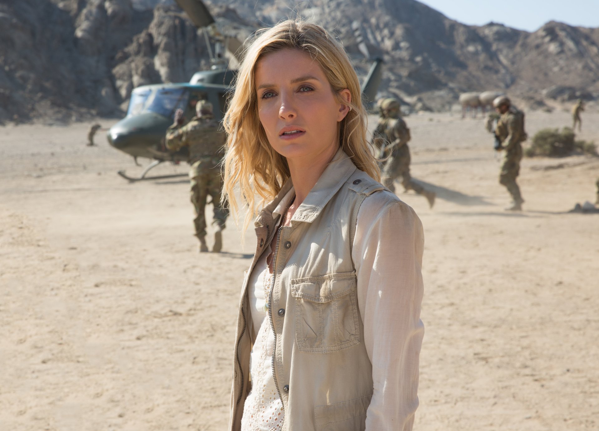HD desktop wallpaper featuring Annabelle Wallis from the movie The Mummy (2017). She stands in a desert landscape with a helicopter and military personnel in the background.