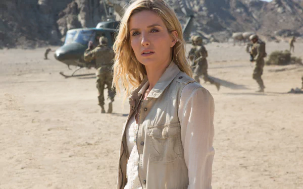 HD desktop wallpaper featuring Annabelle Wallis from the movie The Mummy (2017). She stands in a desert landscape with a helicopter and military personnel in the background.