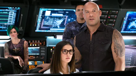 HD desktop wallpaper of a scene from xXx: Return of Xander Cage featuring Ruby Rose and Vin Diesel. They are in a high-tech control room with multiple screens and other characters in the background.
