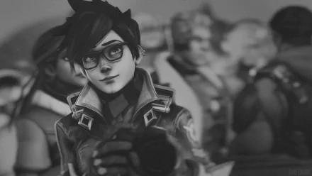 HD PC desktop wallpaper featuring Tracer from the video game Overwatch, showcasing her confident pose with a blurred background of other characters.