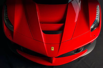 HD wallpaper and background image of a red Ferrari LaFerrari supercar, showcasing the vehicle's sleek hood design and iconic Ferrari emblem from a top-down perspective.