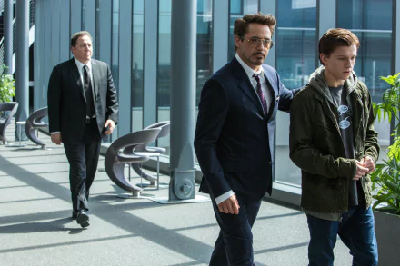 HD desktop wallpaper from the movie Spider-Man: Homecoming featuring Robert Downey Jr. as Tony Stark, Tom Holland as Peter Parker, and Jon Favreau in a modern setting.