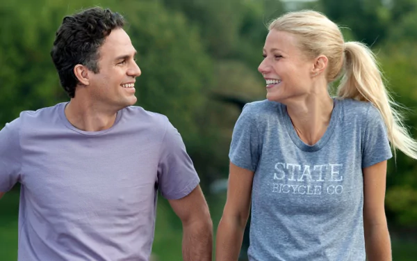 HD desktop wallpaper for the movie Thanks for Sharing showing two actors jogging and laughing together in a green park setting.