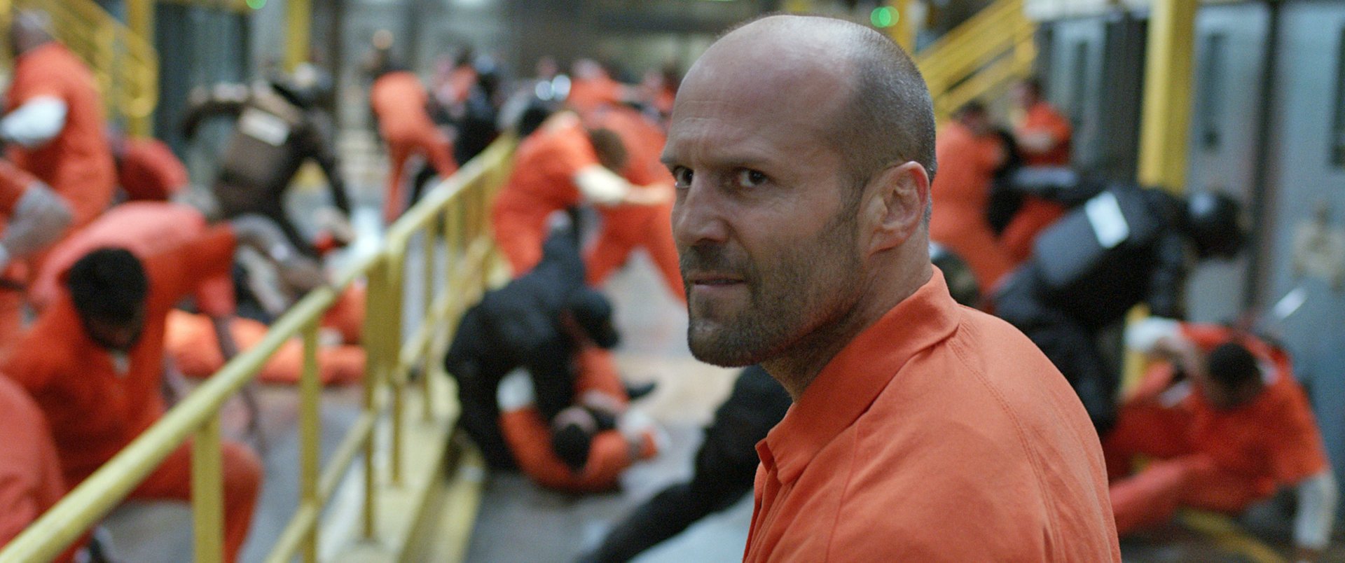 HD PC desktop wallpaper featuring Jason Statham as Deckard Shaw in the movie The Fate of The Furious, set in a prison scene with orange jumpsuits and intense expressions.