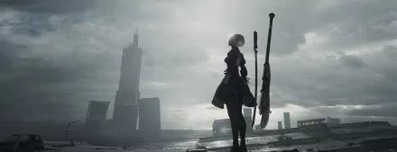 HD desktop wallpaper featuring a character from the video game NieR: Automata, standing in a desolate, futuristic cityscape with tall buildings in the background.