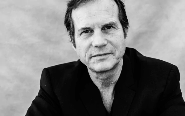 HD desktop wallpaper featuring a monochrome portrait of a man in a black jacket against a plain background.