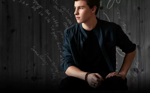 HD desktop wallpaper featuring a contemplative person sitting against a dark background with script.