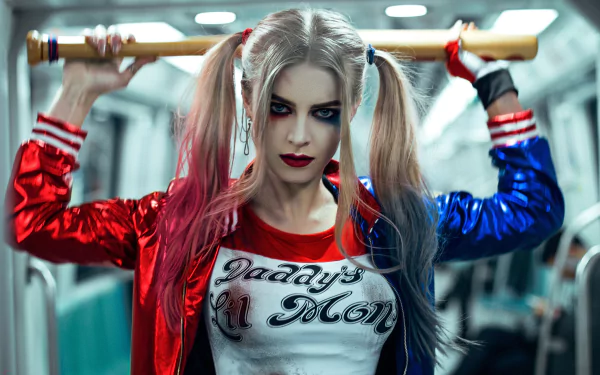 A woman cosplaying as Harley Quinn holds a bat behind her shoulders in a HD desktop wallpaper and background image. She wears the character's iconic makeup and outfit.