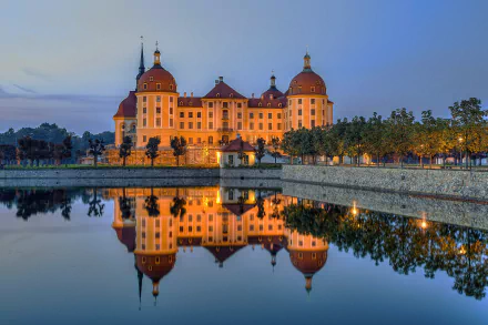 Night view of Moritzburg Castle in Germany with its illuminated architecture reflected clearly on the calm lake water, captured in HD for a desktop wallpaper.