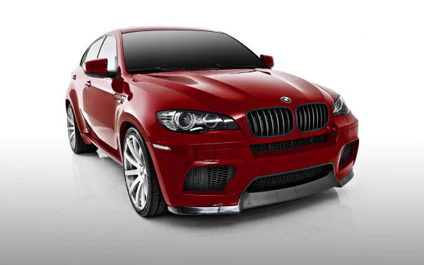 Red BMW X6 SUV car shown in a low-angle front three-quarter view on a white background — HD PC desktop wallpaper and background.