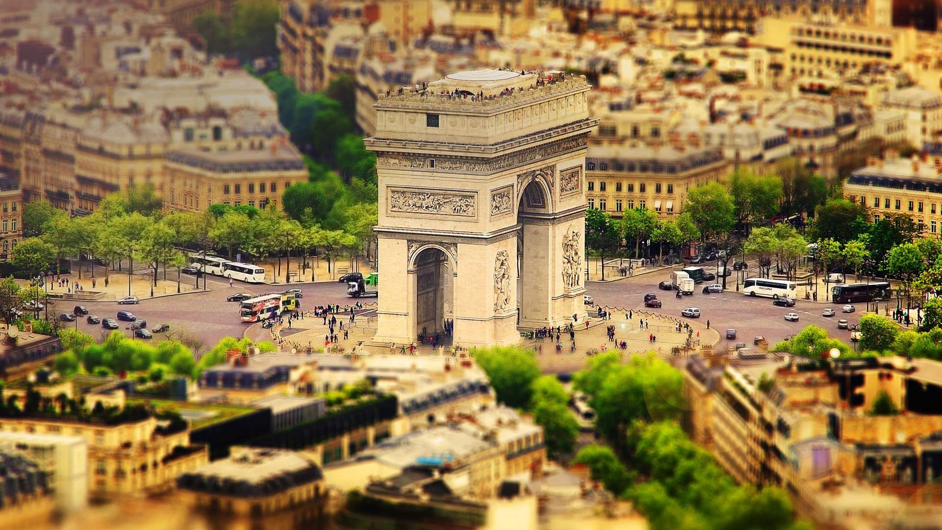 Tilt-shift aerial view of the Arc de Triomphe in Paris, France—miniature-style cityscape and architecture; HD PC desktop wallpaper of the man-made monument.