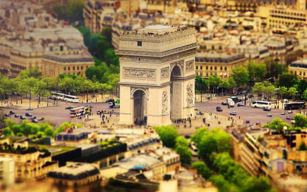 Tilt-shift aerial view of the Arc de Triomphe in Paris, France—miniature-style cityscape and architecture; HD PC desktop wallpaper of the man-made monument.
