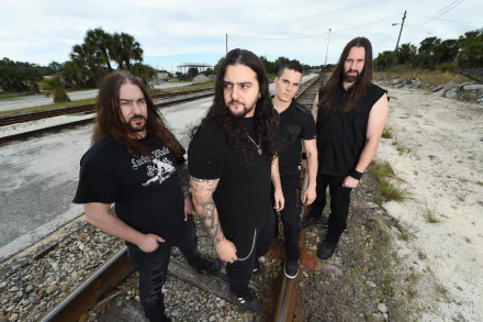 Four long-haired musicians in black on train tracks, gritty outdoor death metal/heavy metal band portrait — music-themed HD PC desktop wallpaper background.
