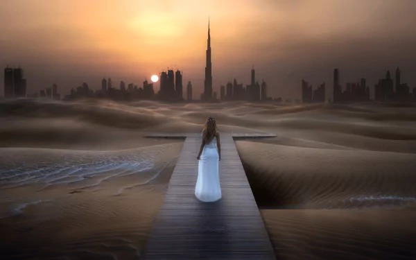 A woman in a white dress walks on a wooden path through a desert toward the Burj Khalifa skyscraper at sunset in this surreal HD cityscape wallpaper.