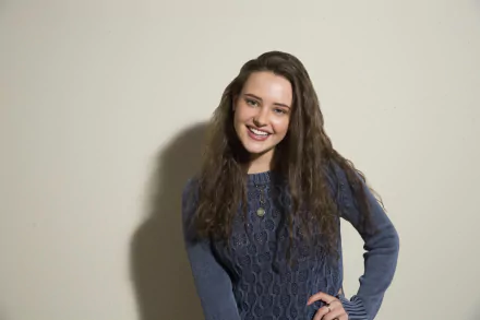 HD wallpaper of Australian actress Katherine Langford, a brunette with a bright smile, posing in a blue sweater.