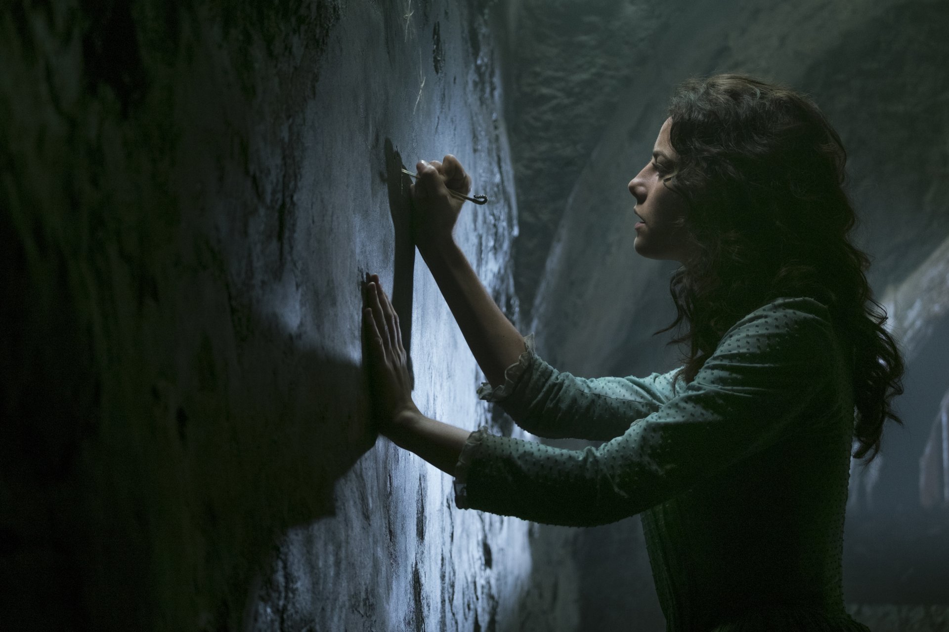 Carina Smyth, played by Kaya Scodelario in Pirates of the Caribbean: Dead Men Tell No Tales, examines an ancient wall in a 4K Ultra HD movie wallpaper.