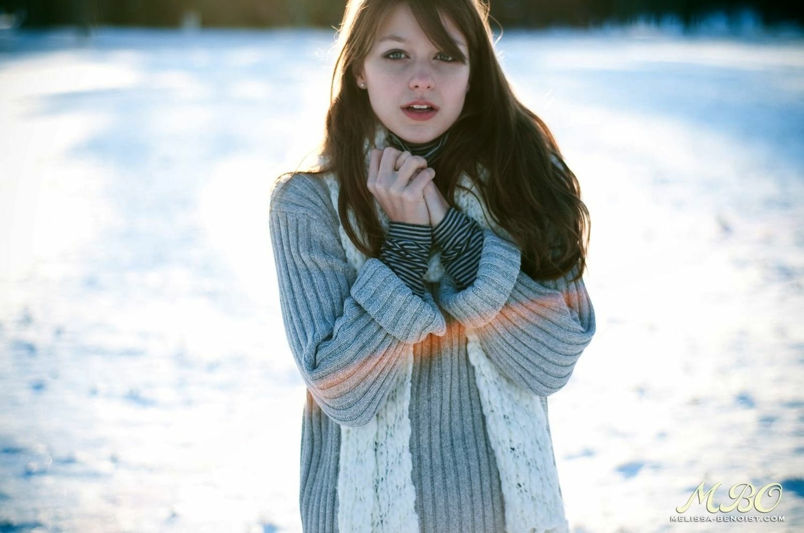 HD desktop wallpaper featuring actress and celebrity Melissa Benoist in a cozy sweater, standing outdoors in a snowy setting with soft natural lighting.